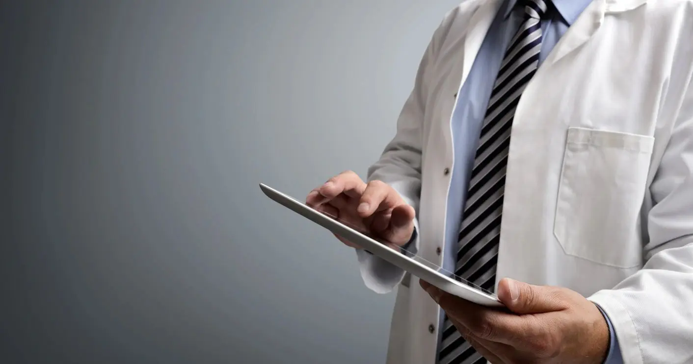 A man in a suit and tie holding an ipad.